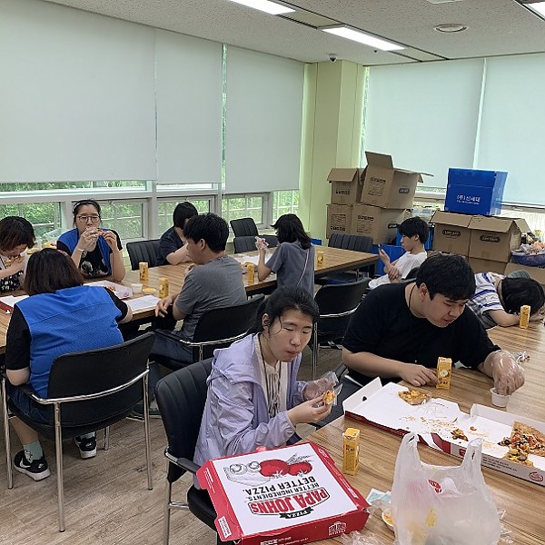 후원받은 피자를 먹고있는 복지관이용자들 모습