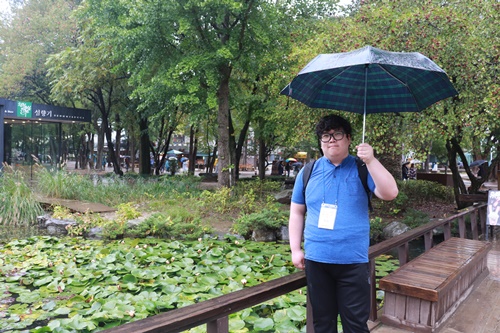 연못앞에서 우산을 쓰고있는 복지관이용자 사진